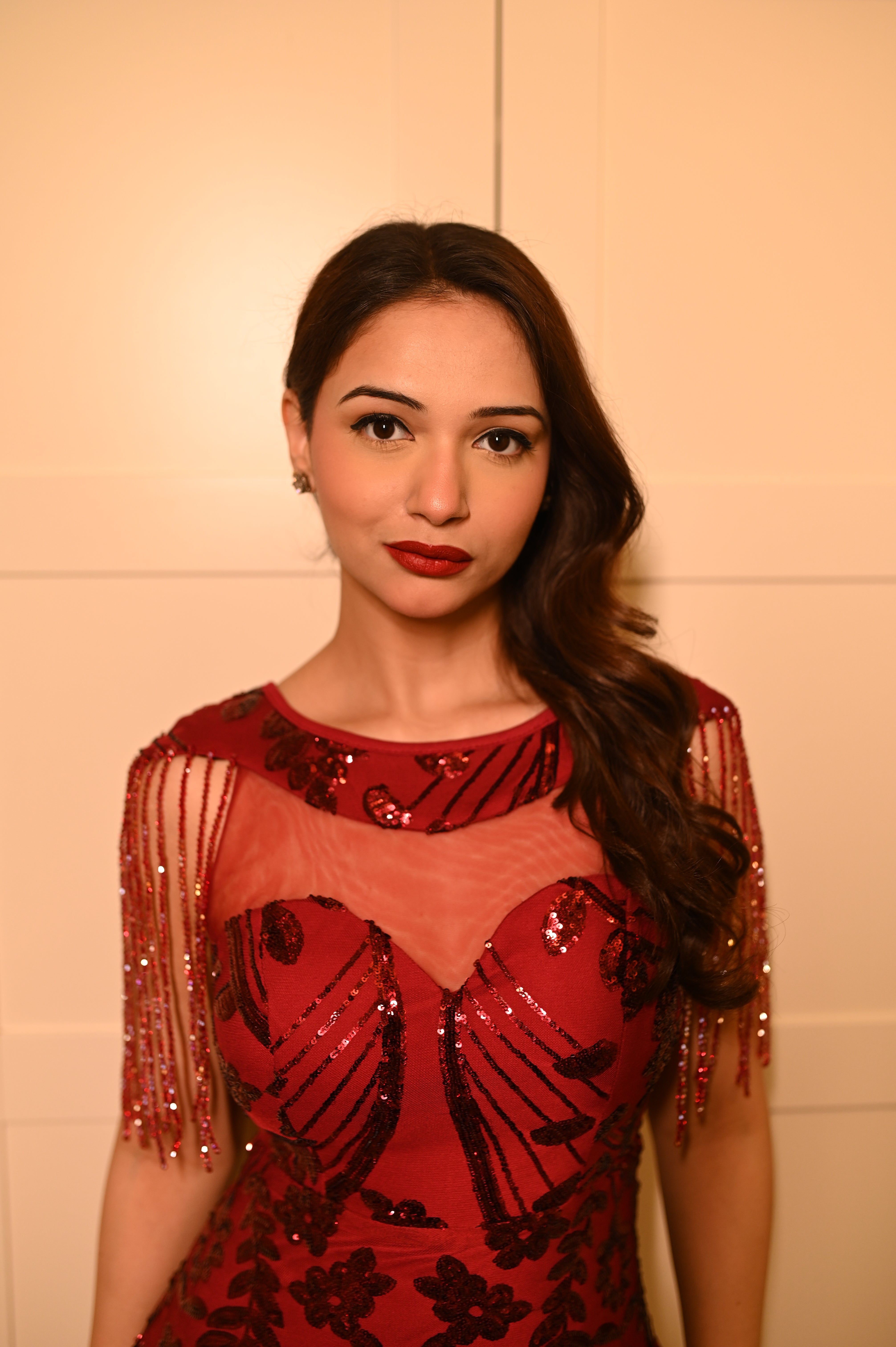 A woman wearing a red dress by Niyara india with floral patterns on the dress