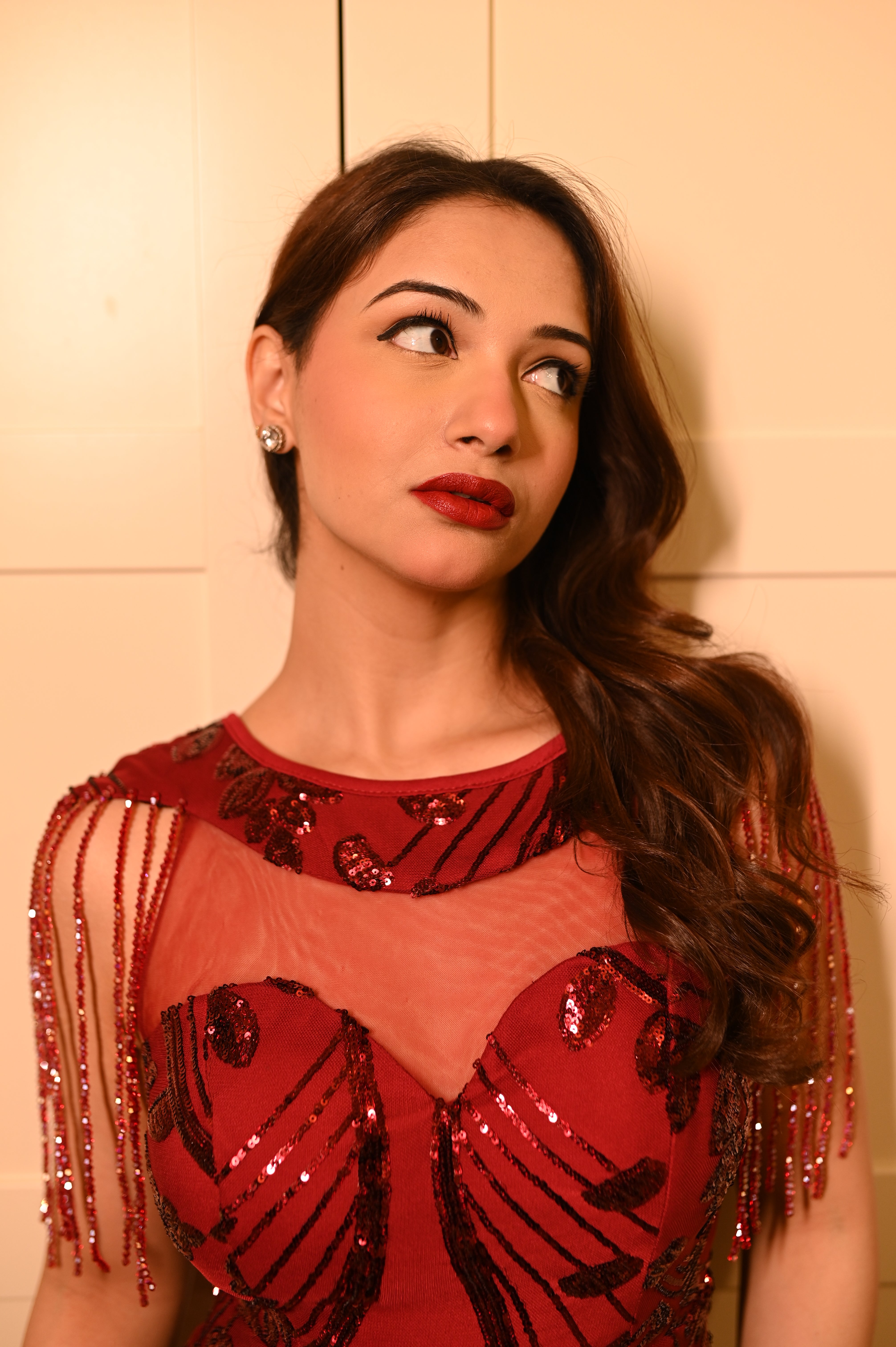 Woman wearing a red sequined outfit by Niyara India with floral designs on the dress