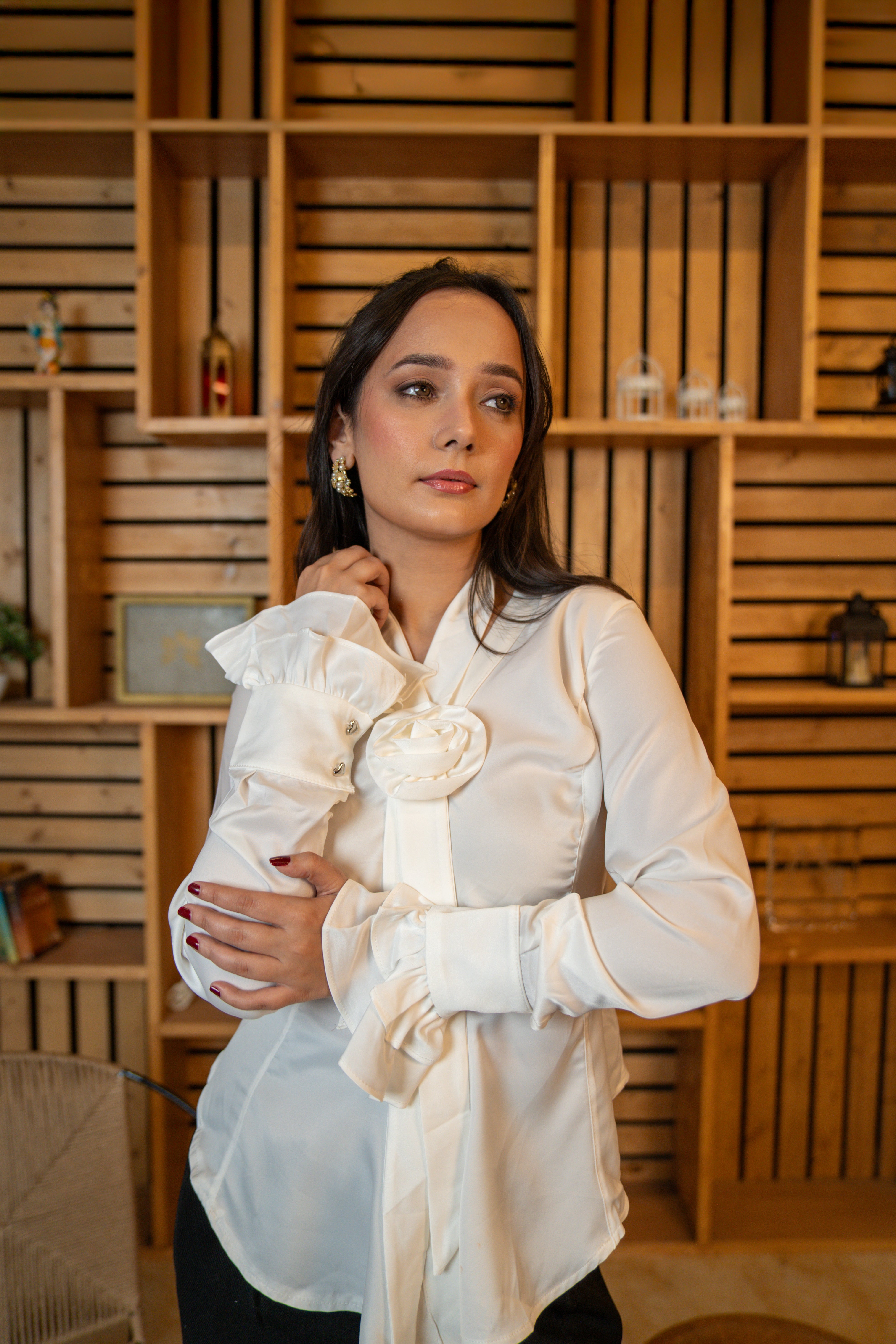 front profile of Woman wearing white satin rosette shirt with flounced sleeves
