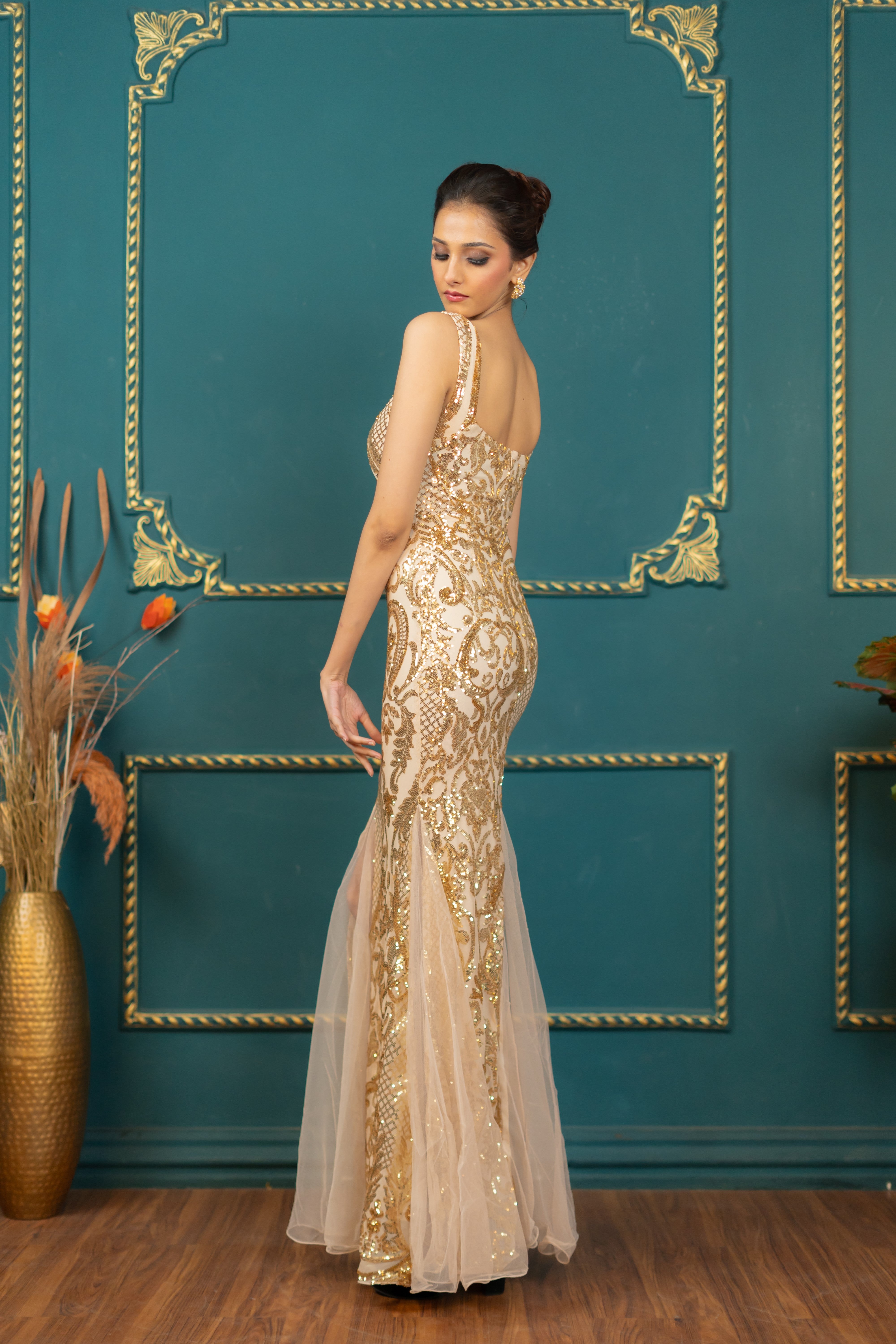 Back view of floor-length gold party gown (right profile)
